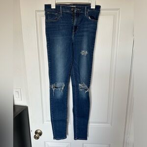 Dark blue Levi skinny jeans with holes.